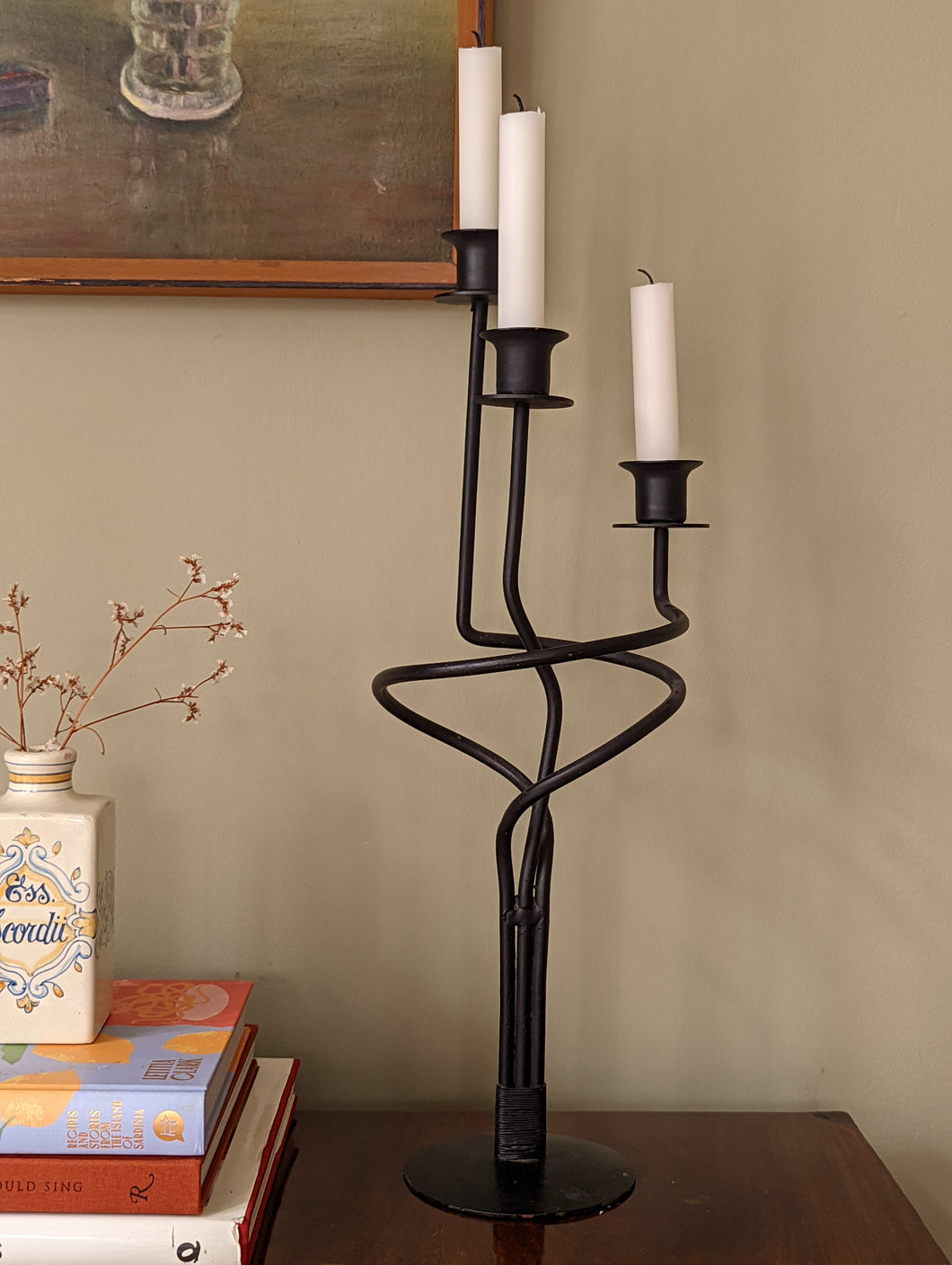 A tall three tiered black metal candlestick holder