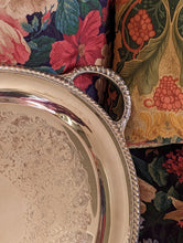 Load image into Gallery viewer, corner of silver tray on floral sofa
