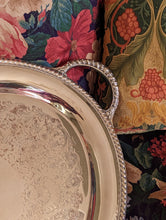 Load image into Gallery viewer, corner of silver tray on floral sofa
