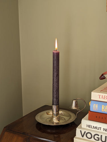Antique silver candlestick holder with snuffer and books