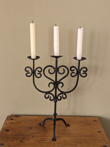 black metal candlestick holder on wooden shelf