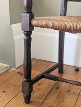 Load image into Gallery viewer, close up view of large oak ladder back rush seat on wooden floor

